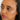 A young woman with dark brown skin and dark brown eyes and black hair is looking off to the left and you can see her cheek bone has a light glow to it. She is wearing 03 glow.